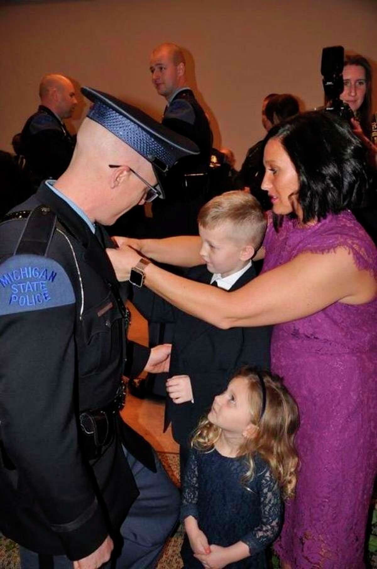 MSP Motor Carrier Officer graduate Joshua Koch is adorned with his badge by his family after his 2019 graduation ceremony. (Courtesy Photo)