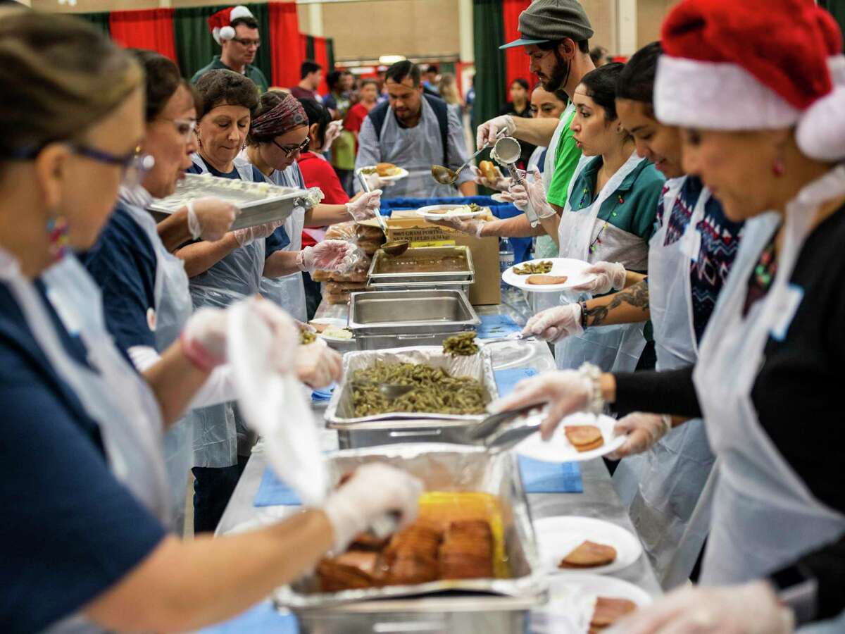 Volunteers, primarily from Frost Bank in this line, fill plates with ham, mashed potatoes and gravy, green beans and a roll during the annual H-E-B Feast of Sharing event at the Henry B. Gonz‡les Convention Center in San Antonio, Texas, on Saturday, December 21, 2019. The event featured live music, photos with Santa, and flu shots. The Feast of Sharing started in 1989 and it's held in 30 cities around Texas and Mexico during the holidays. Free holiday meals also included a slice of apple pie and were served to an estimated 14,000 people.
