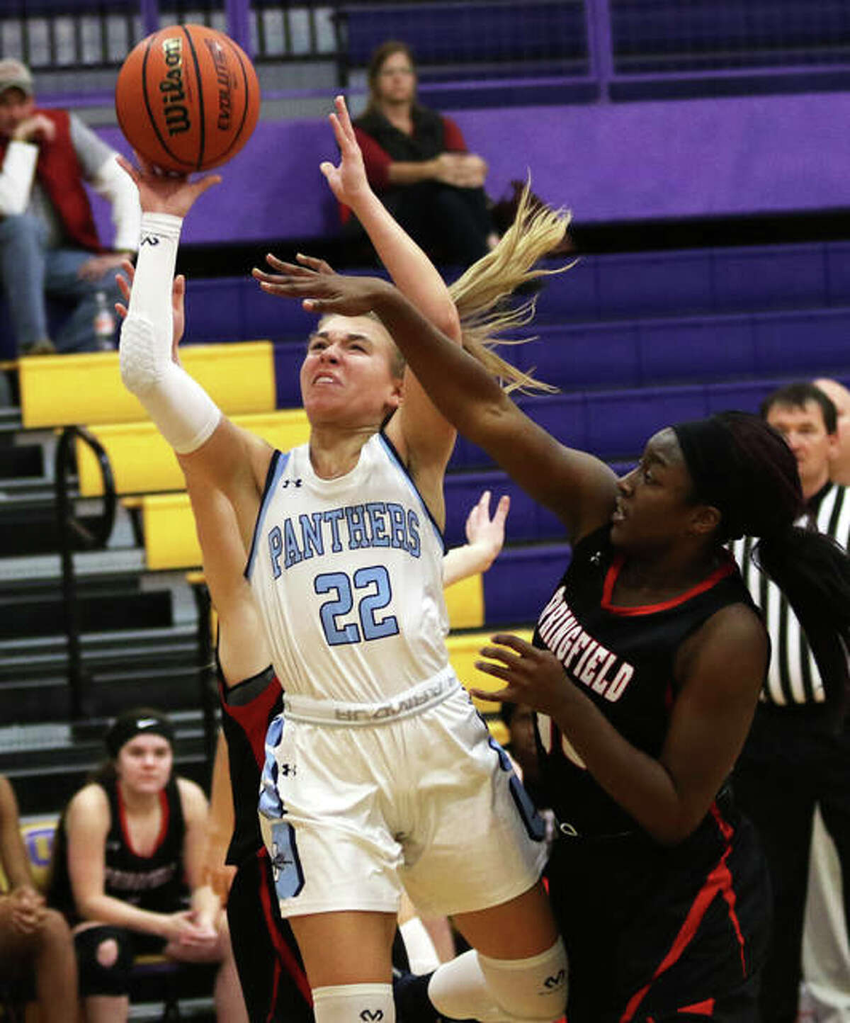 Jersey’s Clare Breden (22) splits defenders to put up a shot contested by Springfield’s Virtuous Komolafe on Saturday night at the CM/Adidas Shootout in Bethalto.