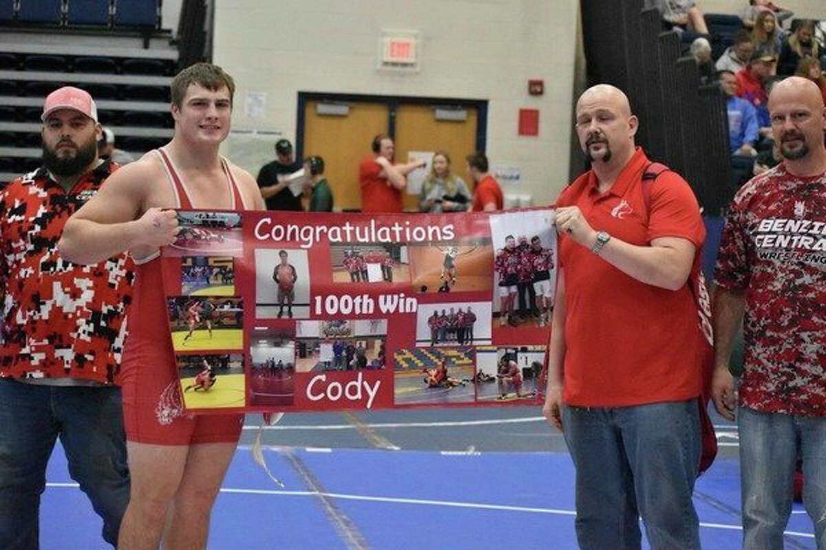 (Pictured left to right) Assistant coach Cody VanDonkelaar, Cody Hanson, coach Josh Lovendusky and father Chad Hanson celebrate Cody's 100th victory. (Courtesy photo/Shane Iverson)