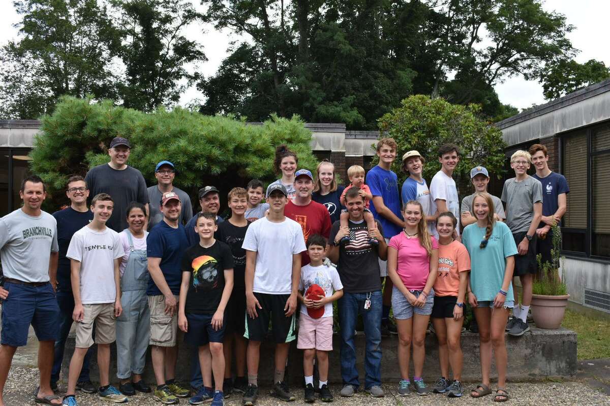 Ridgefield High School junior Luke Nelson, center in hat, helped clean up the courtyard at Branchville Elementary School this fall. Pictured around Nelson is his clean-up crew, including Principal Keith Margolus on the far left.