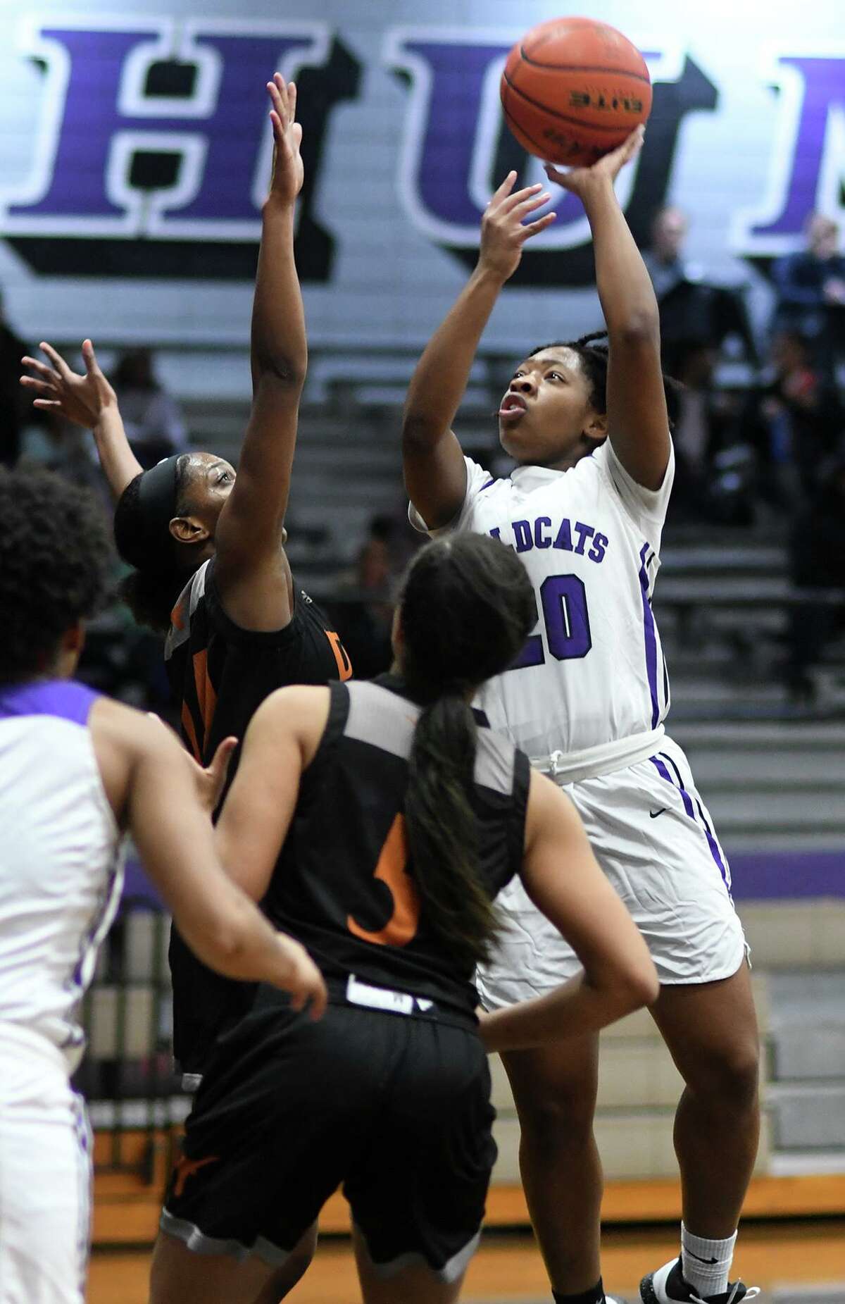 Humble senior Kazarea Taplin (20) drives to the hoop against a pair of Dobie defenders during the first quarter of their district matchup at Humble High School on Dec. 17, 2019.
