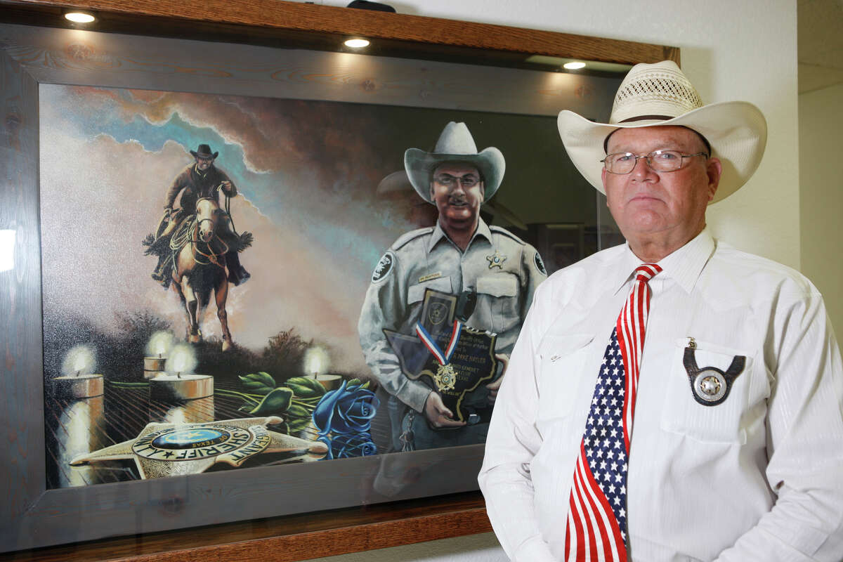 Midland County Sheriff Gary Painter was photographed for USA Today standing with a portrait of Sgt. Mike Naylor in the William Ahders Justice Center that houses the sheriff’s office. Naylor was killed Oct. 9, 2015, while serving a warrant in Midland County.