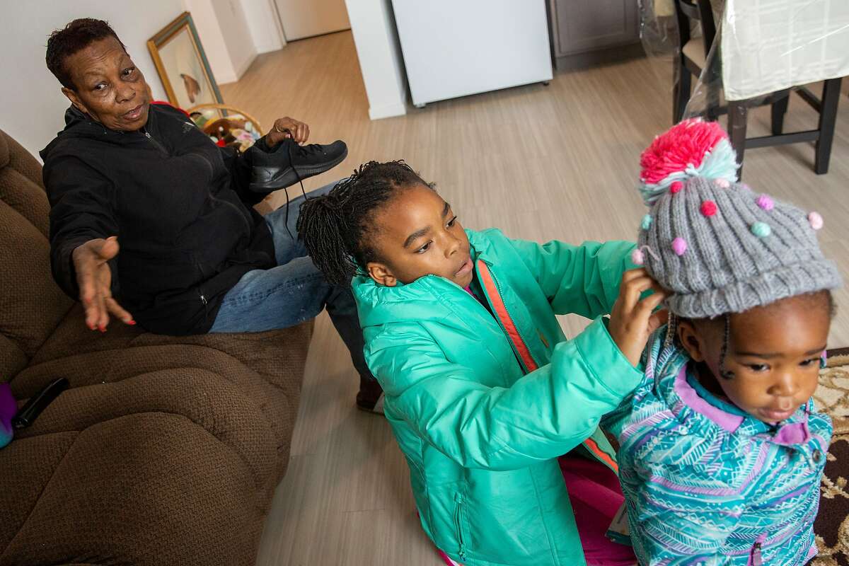 From left: Leola Brown, 69, with her grandchildren Ziani Brown, 8, and Lenia Brown, 2, get ready for their day at their home at BRIDGE Housing on Thursday, Dec. 19, 2019, in San Francisco, Calif. Leola lived across the street at 26th and Wisconsin streets for more than four decades before moving into BRIDGE Housing. The block of her former home is being demolished and developed with hundreds of apartments, as part of the Potrero HOPE SF project.