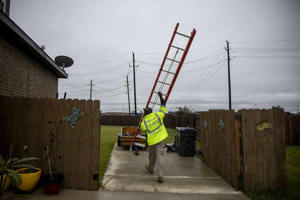 Oâ€™Neil Young, broadband installation technician, carries a ladder as he works on installing broadband internet for a new costumer on Friday, October 25, 2019 in Mont Belvieu, Texas. Major internet service providers don't see enough potential return on investment to make their service available in rural areas. The town of Mont Belvieu decided to spend millions of dollars to build and maintain a municipal internet network, MBLink. MBLink provides affordable broadband internet for all of its residents who want it. (Shaban Athuman/Dallas Morning News/TNS)