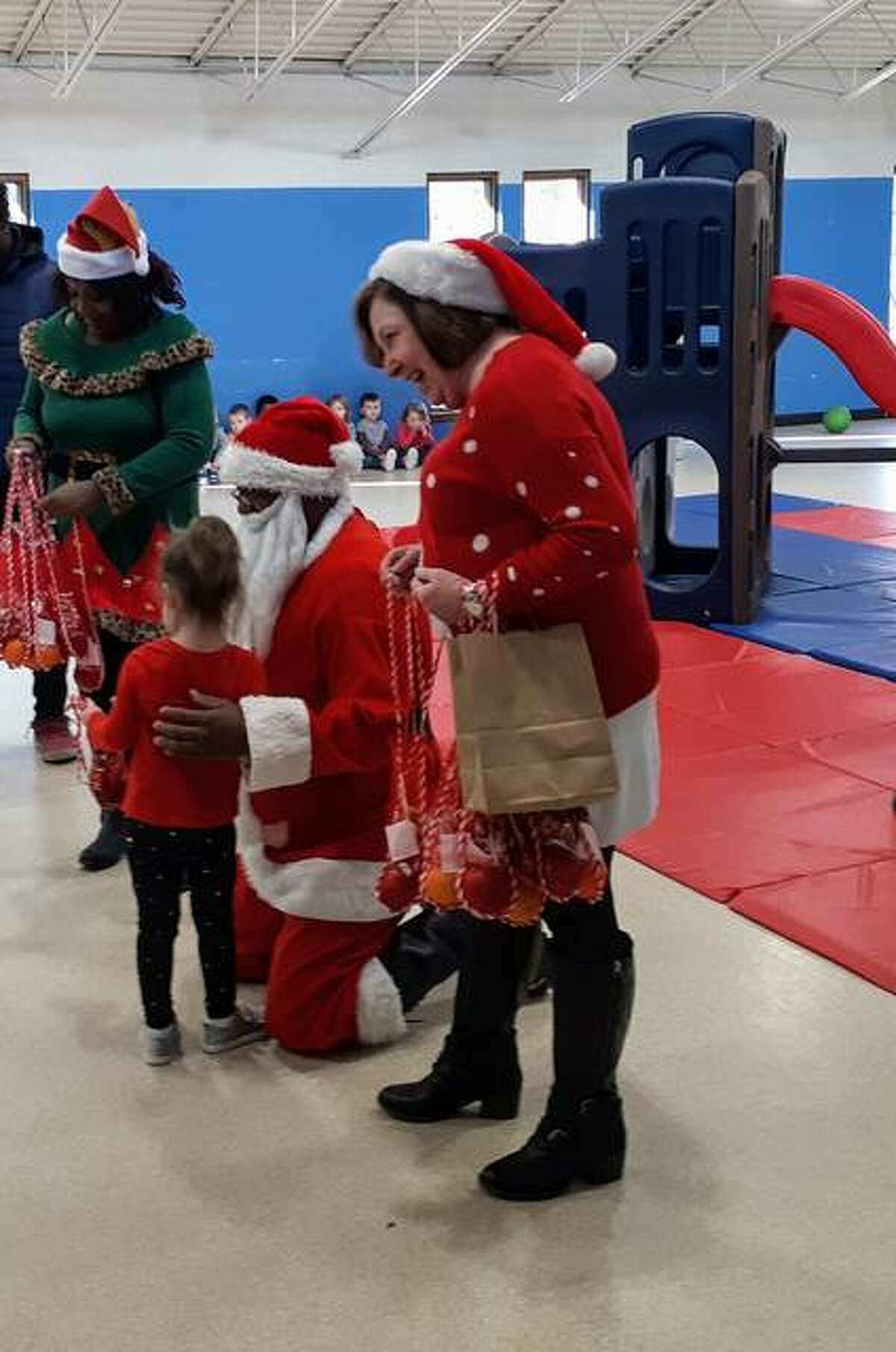 State Rep. Monica Bristow and Rosetta Brown help Santa hand out treats to the kids at St. Francis Daycare at St. Anthony’s Hospital in Alton on Monday.
