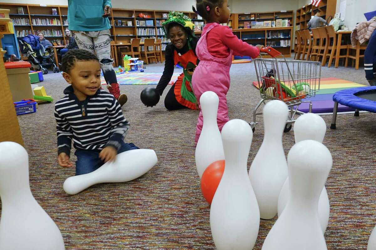 Shanae Lawrence, background center, the Arbor Hill Elementary Community School site coordinator, plays with Semaj Johnson, 4, left, and Milani Smith, 1, right, at the Play, Learn, Soar program at Arbor Hill Elementary School on Tuesday, Dec. 17, 2019, in Albany, N.Y. (Paul Buckowski/Times Union)