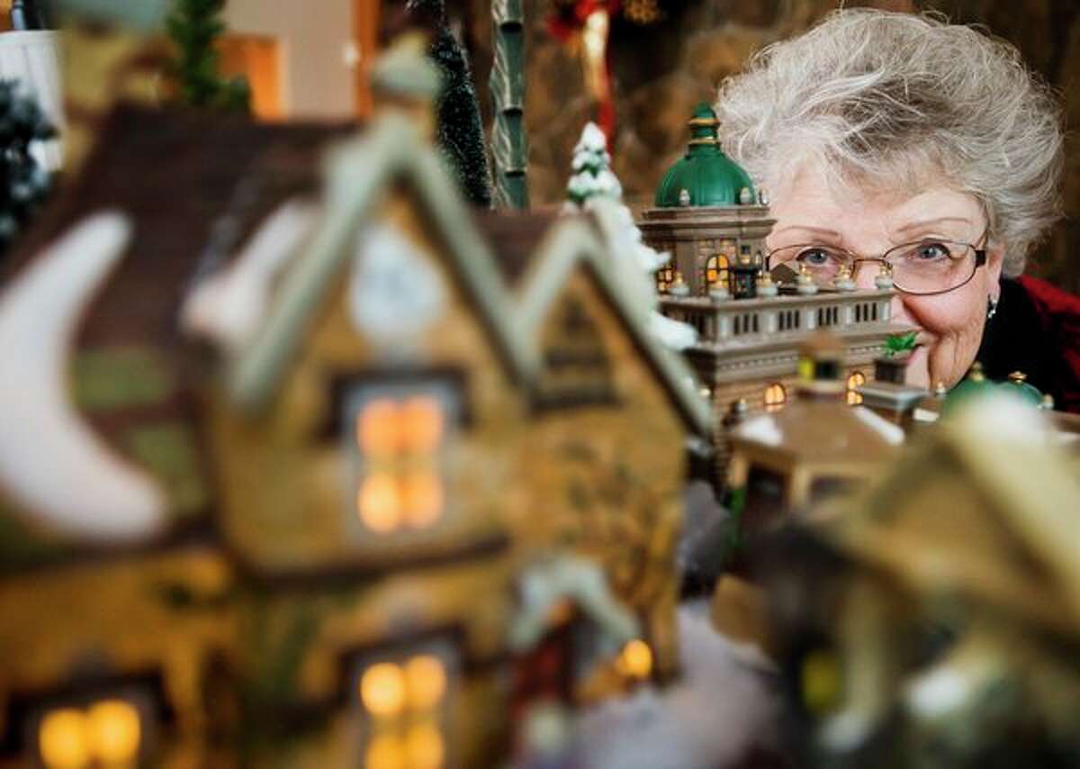 Kay Pfenninger poses for a portrait with her elaborate Dickens' Village collection Thursday at her home in Midland. (Katy Kildee/kkildee@mdn.net)