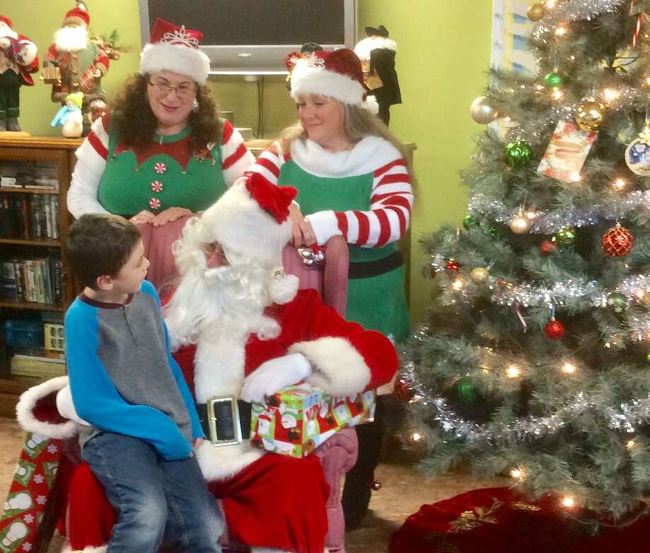 FISH held its Cookies &amp; Cocoa party for the shelter's children on Dec. 20. Above, staff members dressed as elves join Santa to hear a little boy’s Christmas wishes. Photo: Deirdre DiCara / Contributed Photo /