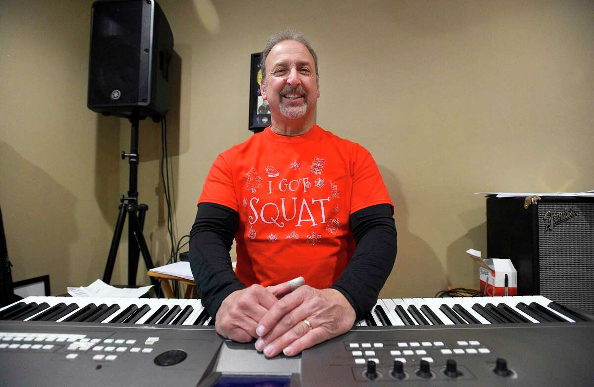 Mike Giordano, photograph at his Stamford home on Dec. 20, 2019, is a Stamford mail carrier who also writes silly Christmas songs. A couple of years ago, he put out a Christmas album titled "It Ain't Christmas Til I'm Drunk." This December he released a video for one of the songs, "I Got Squat." The piano player, who has been in a number of local bands, also recently released a Christmas-themed podcast where he plays characters with his two good friends and riffs on some of the songs he's written.