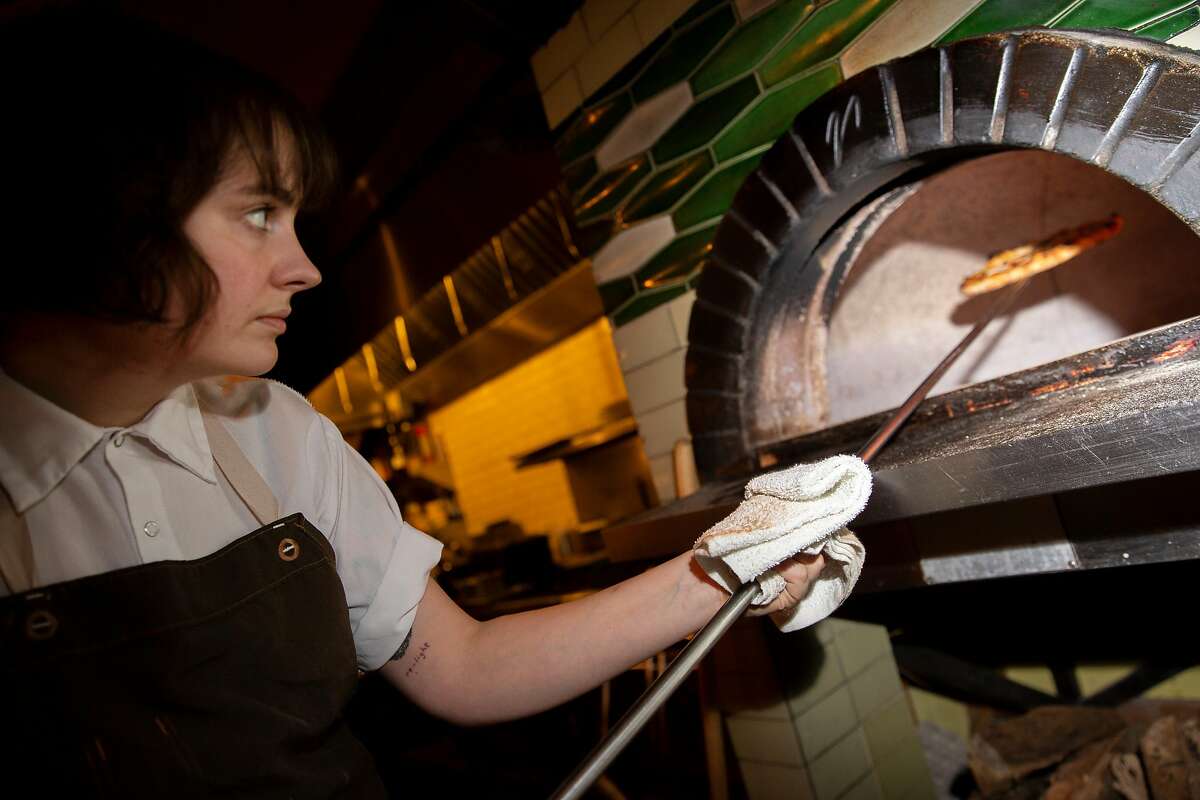 Madeline Kenney cooks a pizza at Sister on Thursday, Dec. 19, 2019, in Oakland, Calif. The restaurant is located at 3308 Grand Ave.