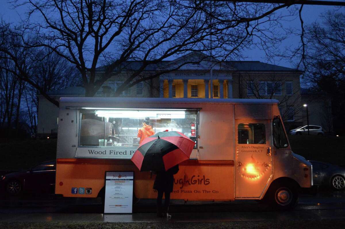 There was lots of rain, but a hungry visitor still patronizes the food truck on Veterans Green at the First Light Festival at the Westport Historical Society, Monday, Dec. 31, 2018, in Westport, Conn.