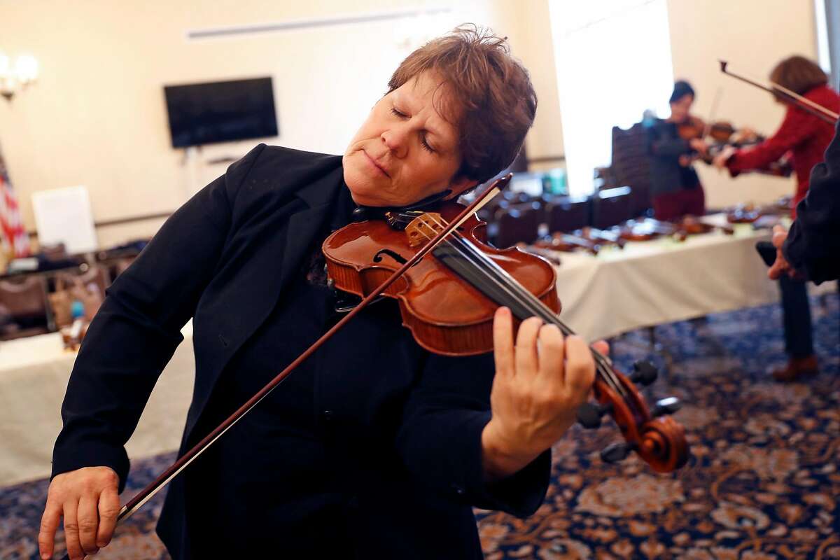 San Francisco Opera Orchestra string quartet member Dawn Harms tests a violin from Violins of Hope, a multi-organizational project built around a collection of violins that were played in concentration camps and ghettos during the Holocaust, at Veteran's Building in San Francisco, Calif., on Wednesday, December 18, 2019.