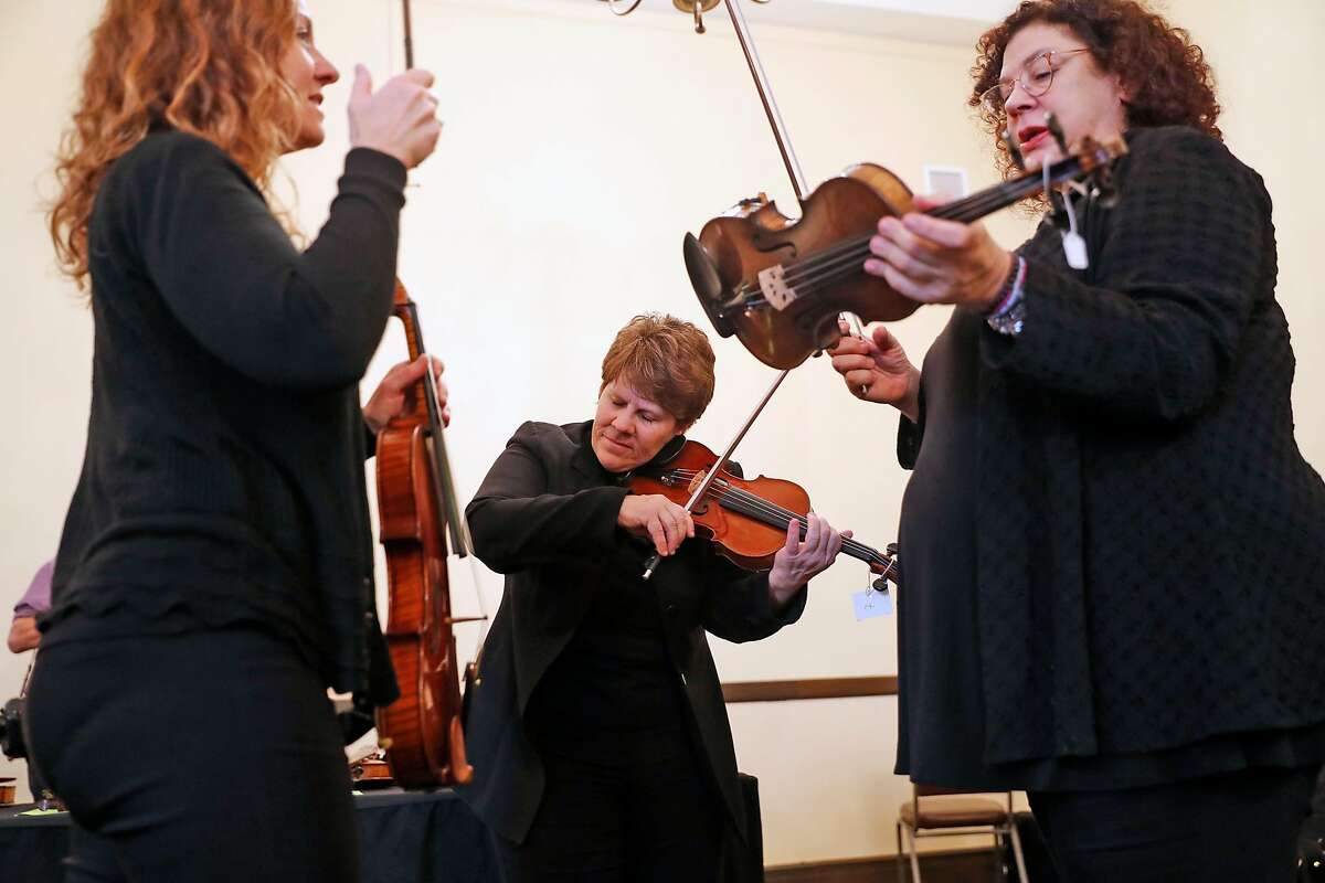 (left to right) San Francisco Opera Orchestra string quartet members Elizabeth Prior, Dawn Harms and Kay Stern test violins from Violins of Hope, a multi-organizational project built around a collection of violins that were played in concentration camps and ghettos during the Holocaust, at Veteran's Building in San Francisco, Calif., on Wednesday, December 18, 2019.