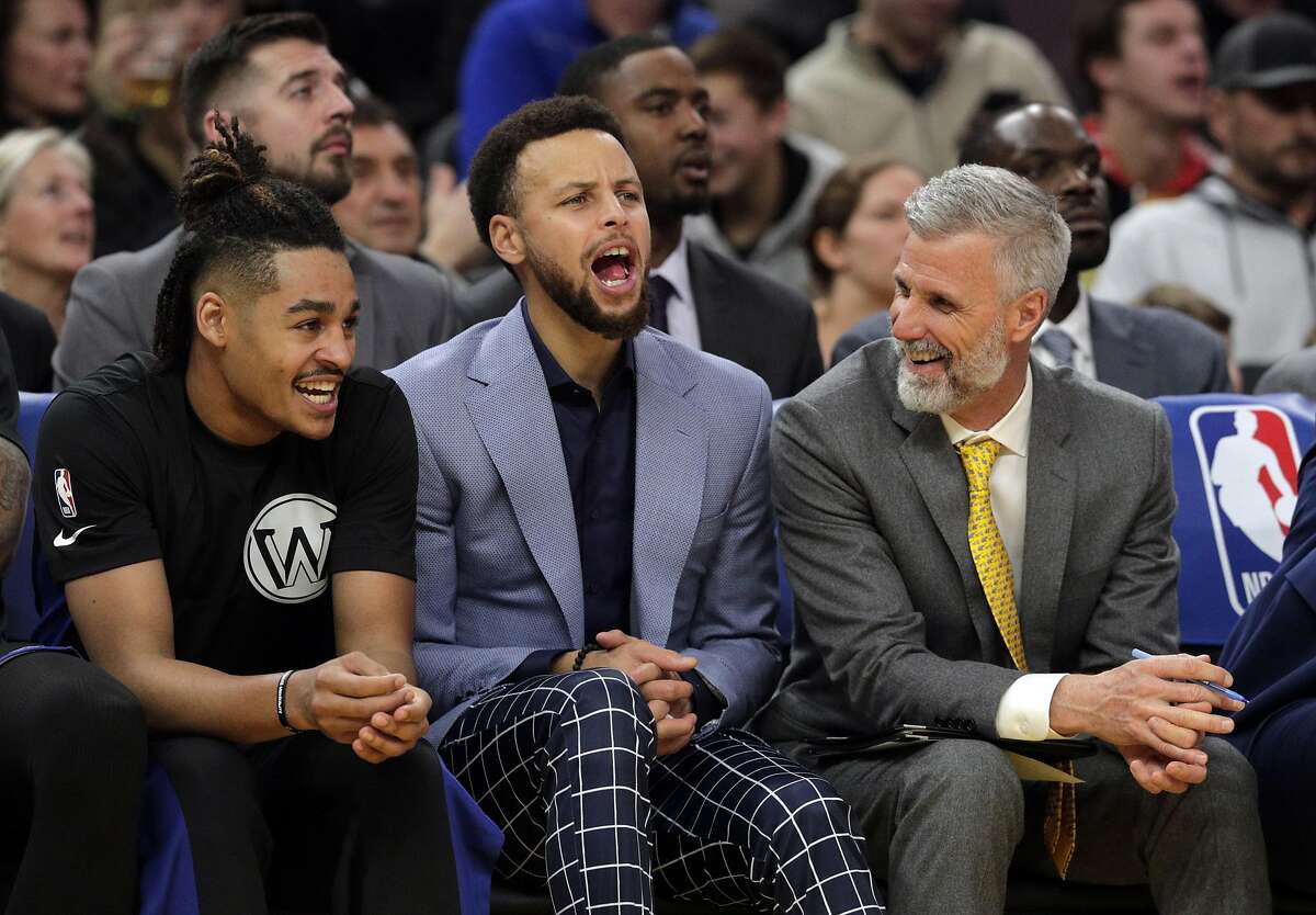 Stephen Curry (30) cheers from the bench with Jordan Poole (3) and coach Bruce Fraser in the second half as the Golden State Warriors played the Houston Rockets at Chase Center in San Francisco, Calif., on Wednesday, December 25, 2019.