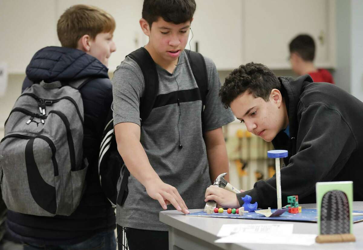 Ilian Villegas, right, and Abraham Guerrero, center, both 8th graders at The Advanced Learning Academy at Fox Tech High School, work on an engineering project.