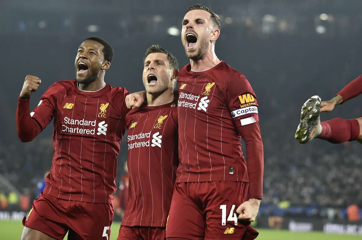 Liverpool's James Milner, second left, celebrates with his teammate Liverpool's Georginio Wijnaldum, left, and Liverpool's Jordan Henderson after scoring his side's second goal during the English Premier League soccer match between Leicester City and Liverpool at the King Power Stadium in Leicester, England, Thursday, Dec. 26, 2019. (AP Photo/Rui Vieira)