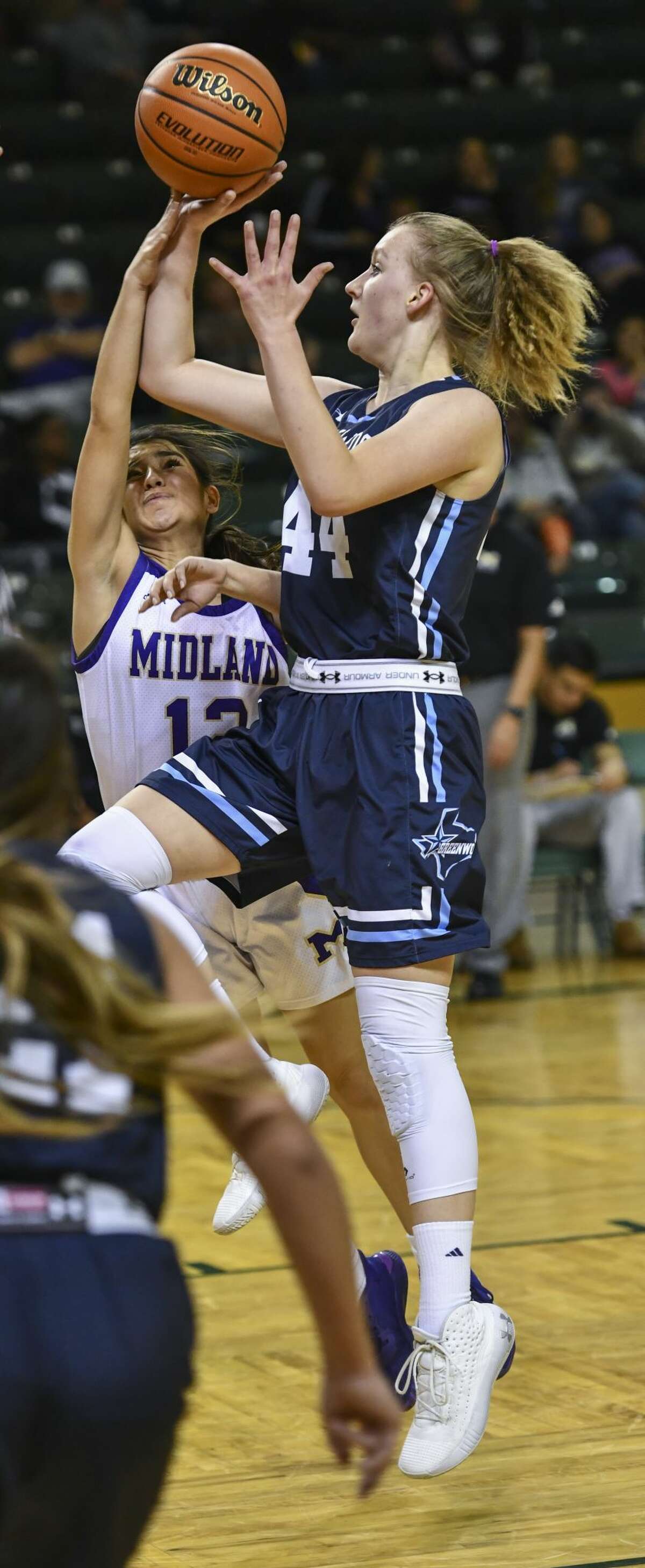 Greenwood's Madeleine Mathes shoots the ball as Midland High's Lauren Jones tips the ball Thursday, Dec. 26, 2019 at Chaparral Center.