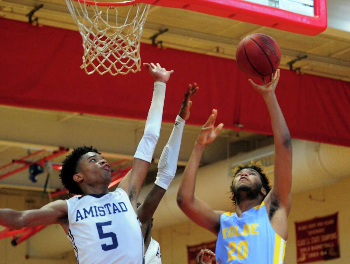 Kolbe Cathedral’s Jalen Sullivan lays up the ball as Amistad’s Jaden Ratliff defends during the Robert Saulsbury Basketball Invitational in New Haven on Friday.