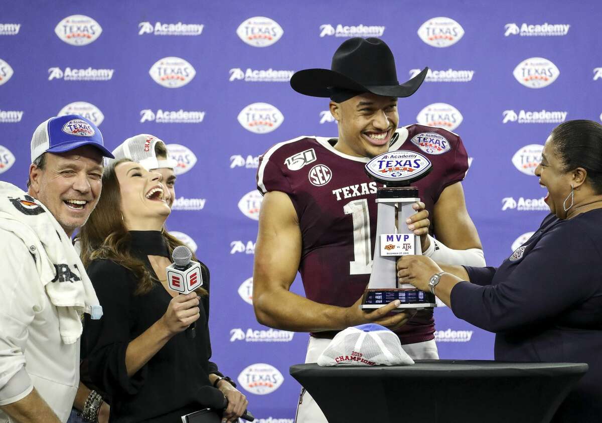 Texas A&M Aggies quarterback Kellen Mond (11) laughs with Texas A&M Aggies head coach Jimbo Fisher, left, as he is given the MVP trophy after the Texas A&M Aggies beat the Oklahoma State Cowboys in the Texas Bowl at NRG Stadium on Friday, Dec. 27, 2019, in Houston.