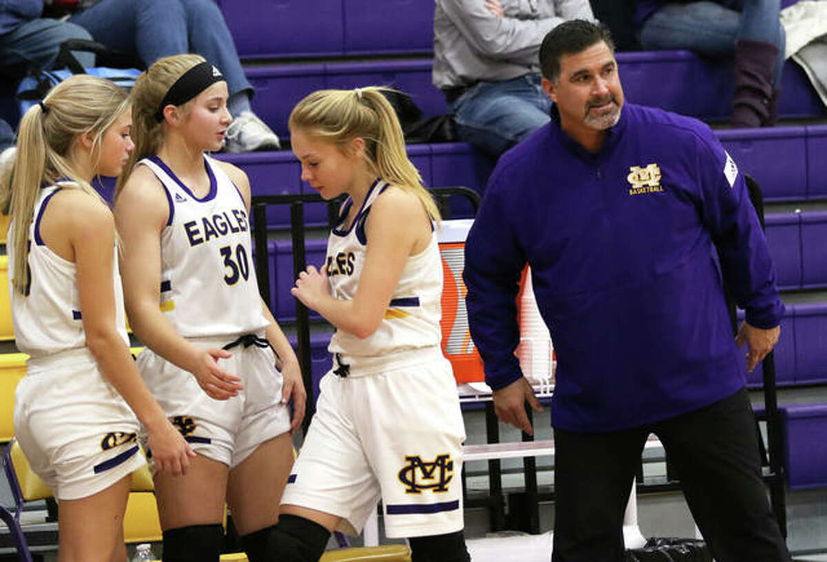 CM coach Jonathan Denney (right) delivers a final word to Tori Standefer, who joins teammates Jenna Christeson (30) and Kelbie Zupan (left) on the Eagles bench during a CM/Adidas Shootout game vs. O’Fallon on Dec. 20 in Bethalto. Denney picked up career win No. 300 on Friday night.
