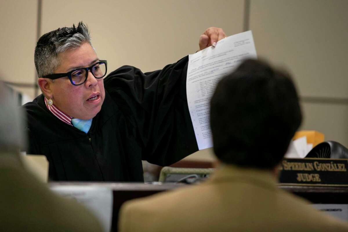 Judge Rosie Speedlin-Gonzalez shows a defendant a document during proceedings in County Court-at-Law 13 in the Cadena-Reeves Justice Center in San Antonio on Dec. 19, 2019.