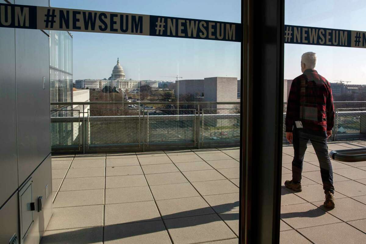 In this Friday, Dec. 20, 2019, photo, a man walks onto the terrace with the Capitol in the background at the Newseum in Washington. The Newseum will close the Pennsylvania Avenue location on Dec. 31, 2019. It attracted millions of visitors but lacked a solid financial plan to stay afloat. The mission of the Newseum is to increase public understanding of the importance of a free press and the First Amendment. (AP Photo/Jacquelyn Martin)