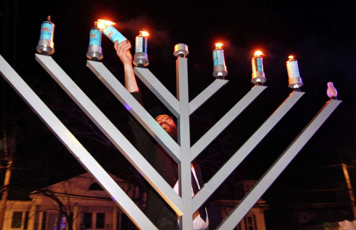 Rabbi Schneur Wilhelm, with Chabad Jewish Center of Milford-Hebrew Congregation of Woodmont, celebrates during a Menorah Lighting for the 7th night of Chanukah on the Milford Green in Milford, Conn., on Saturday Dec. 28, 2019. This is annual event brings the Jewish community together, as the candles are lit and songs are sung in an outdoor display of Jewish pride.