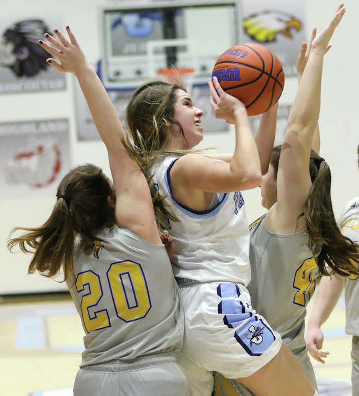 Jersey’s Abby Manns manages to score in tight quarters between Taylorvill’es Kristina Allen and Meghan Donnan during a Panthers’ win Friday in the Deck the Halls with Basketballs Tourney at Havens Gym in Jerseyville. The Panthers will play Marquette for the tourney title on Monday night.