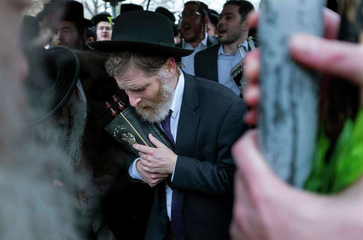 Community members celebrate the arrival of a new Torah near the rabbi's residence, Sunday, Dec. 29, 2019, in Monsey, N.Y. A day earlier, a knife-wielding man stormed into the home and stabbed multiple people as they celebrated Hanukkah in the Orthodox Jewish community.