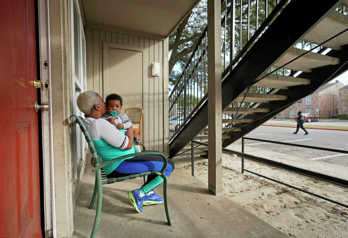 Shaunta Smith kisses her 7-month-old grandson, Trevion Easter, Jr., as she sits outside her apartment at Haverstock Hills, 5619 Aldine Bender Rd., Thursday, Dec. 5, 2019, in Houston. Prairie View A&M University is partnering with Haverstock Hills, a low-income apartment complex that has been notorious for crime and drugs, in hopes of creating a pathway to college for youth. The university will offer a range of services to the community, much of which will be directed toward students and juveniles, including college prep programs, family empowerment programs and support groups for parents, health awareness and services that address juvenile delinquency.
