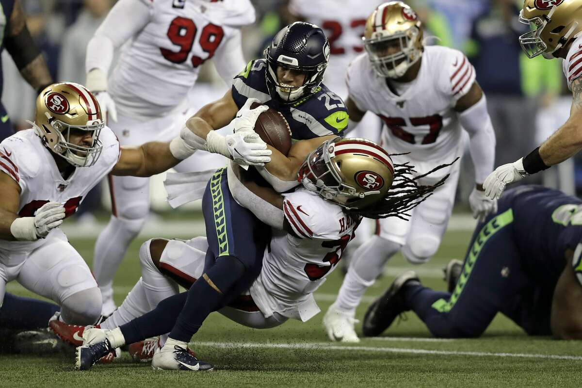 Seattle Seahawks running back Travis Homer (25) is brought down by San Francisco 49ers' Marcell Harris on a carry during the first half of an NFL football game, Sunday, Dec. 29, 2019, in Seattle. (AP Photo/Stephen Brashear)