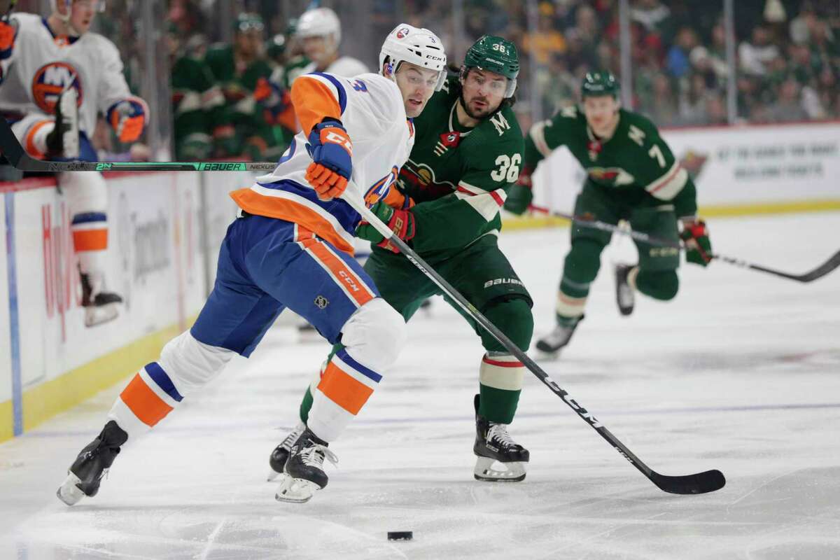 Minnesota Wild right wing Mats Zuccarelllo (36) and New York Islanders defenseman Adam Pelech (3) battle for the puck in the first period of an NHL hockey game Sunday, Dec. 29, 2019, in St. Paul, Minn. (AP Photo/Andy Clayton-King)