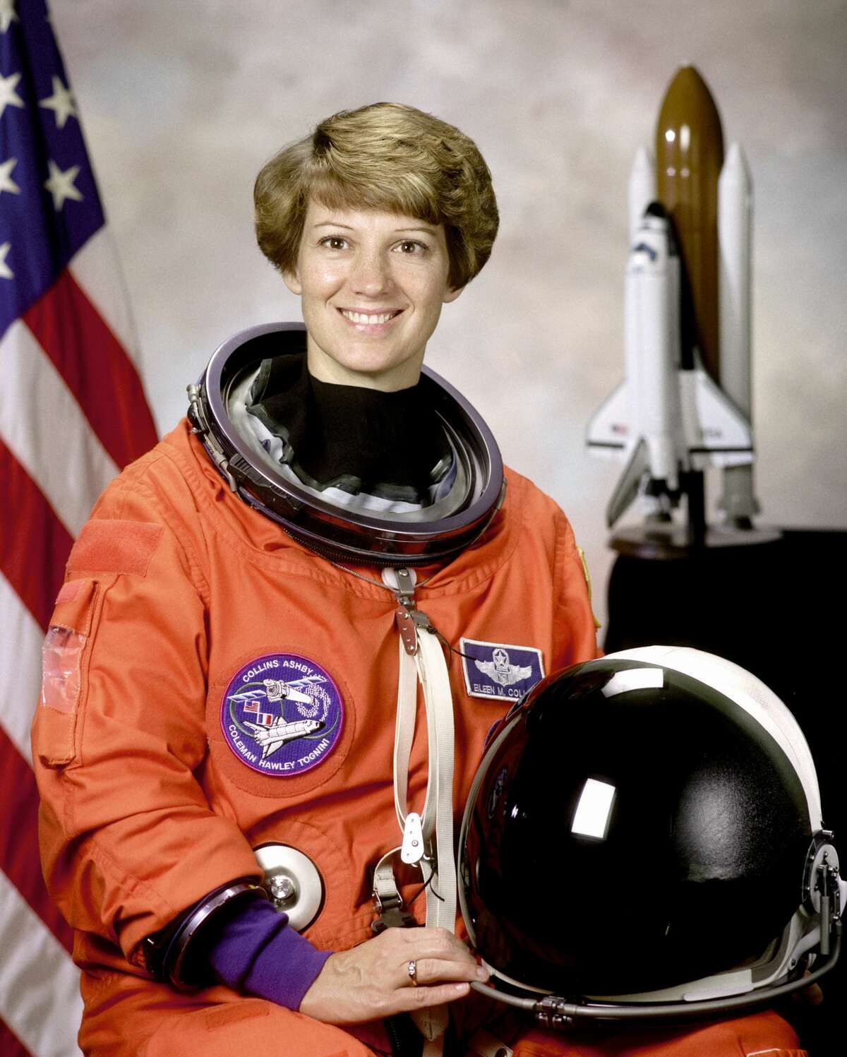 Eileen M. Collins shown wearing an orange Launch and Entry Suit (LES) with helmet. Collins was the first woman to command a Space Shuttle mission.