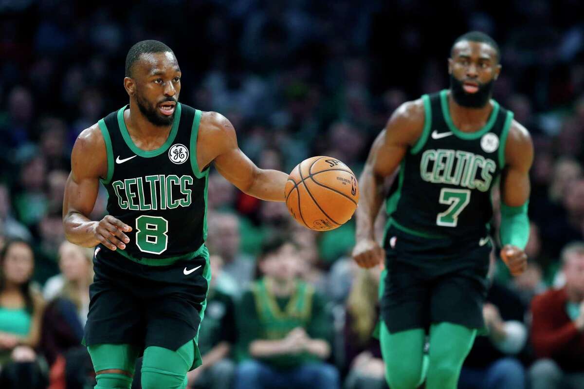 The Boston Celtics’ Kemba Walker (8) and Jaylen Brown play against the Toronto Raptors on Saturday in Boston.