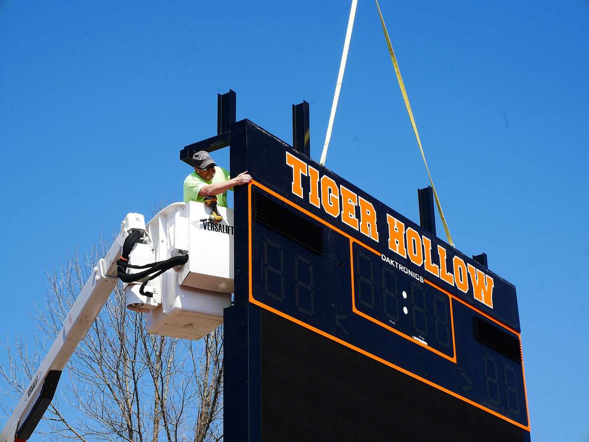 High wire act — Paul Canning of Scoreboard Enterprises lowers a new Tiger Hollow scoreboard onto its frame at Ridgefield High School, Wednesday, April 3. The scoreboard, which cost $225,000 has the capability to project instant-replay videos at the field.