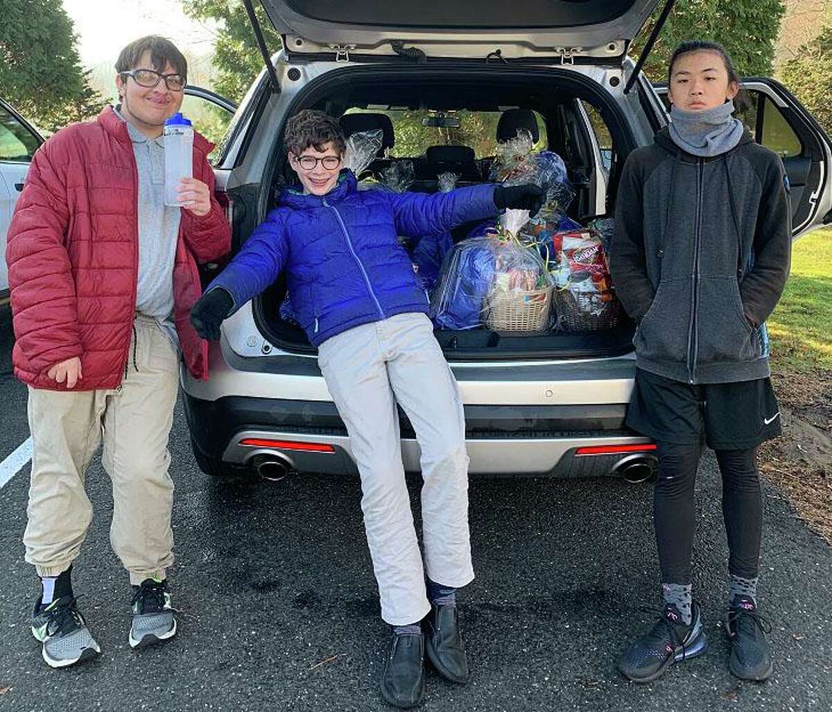 Students from the Glenholme School in Washington recently prepared and delivered Thanksgiving baskets to the Northwest Connecticut Visiting Nurse Association for distribution to local families in need. The baskets were packaged by students and filled with non-perishable food donations from Glenholme staff. The school provided 12 baskets this year, each to be delivered by the VNA. Above, students Ian C., Paul M. and James T. load the car with the baskets. The Glenholme School is a therapeutic boarding and day school for students ages 10-21 with various learning, social and emotional differences.