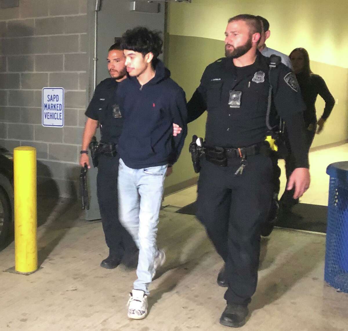Suspects Jonangel Cervantes, 17, is escorted by San Antonio police at police headquarters downtown Monday night. Cervantes was arrested in connection with the Dec. 18 shooting of four people at South Park Mall.
