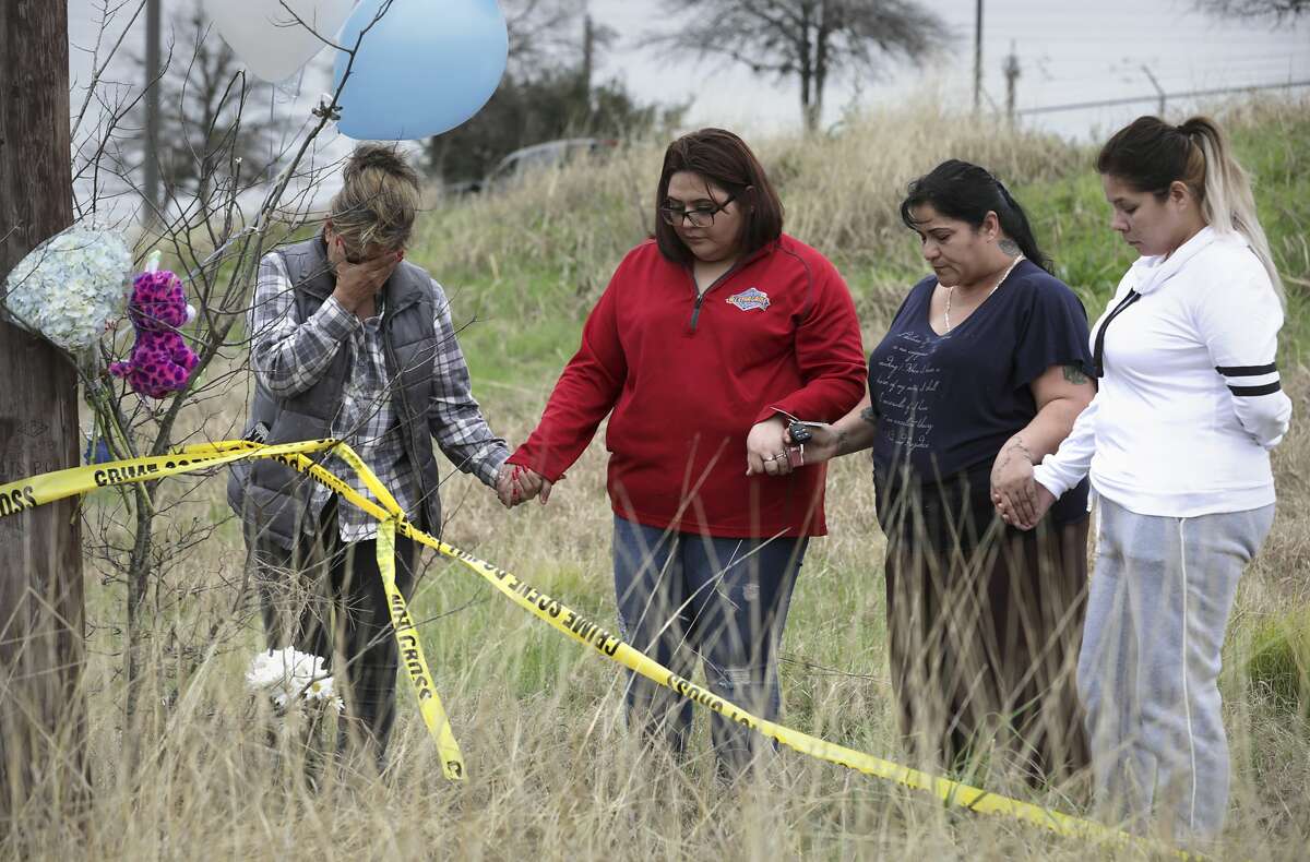Mourners Sylvia Santana, left to right, Diamond Moreno, Margarita Santoya and Mary De La Rosa pray after placing flowers, balloons and stuffed toys near the site where authorities found the body of 8-month-old King Jay Davila wrapped in a blanket and buried in a backpack next to Rosillo Creek by Rittiman Rd., on Friday, Jan. 11, 2019.