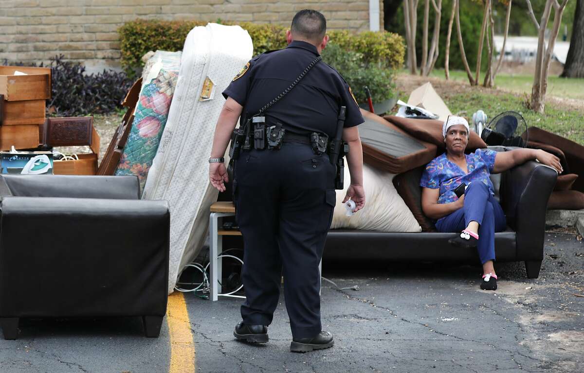 The following photos are from "Kicked Out," the Express-News investigation about evictions in San Antonio. Bexar County Deputy Constable Edward Prado of Precinct 4, center, checks on Patricia A. White as she sits with her possessions after Prado served a writ of possession to White at Brooks Townhomes on Wednesday, Nov. 6, 2019.