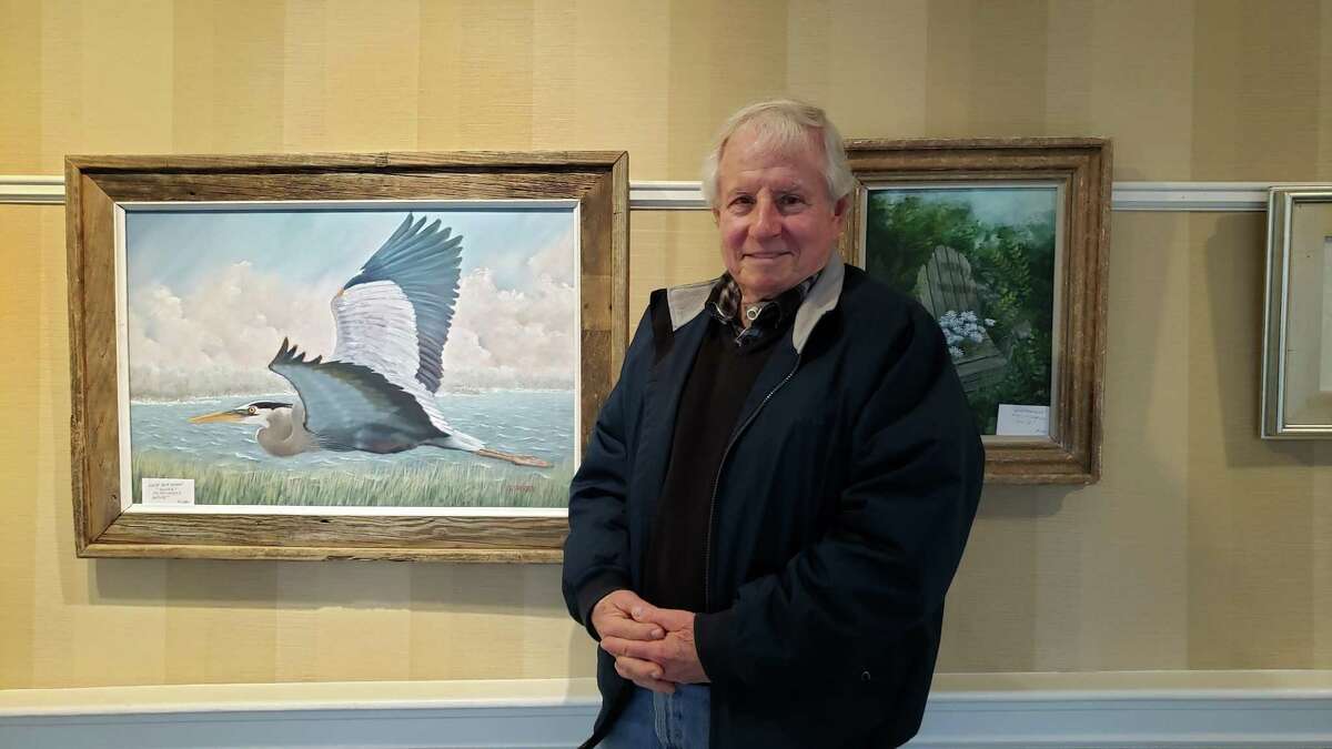 Darien resident Steve Fritsch standing near his artwork at the Atria Darien.