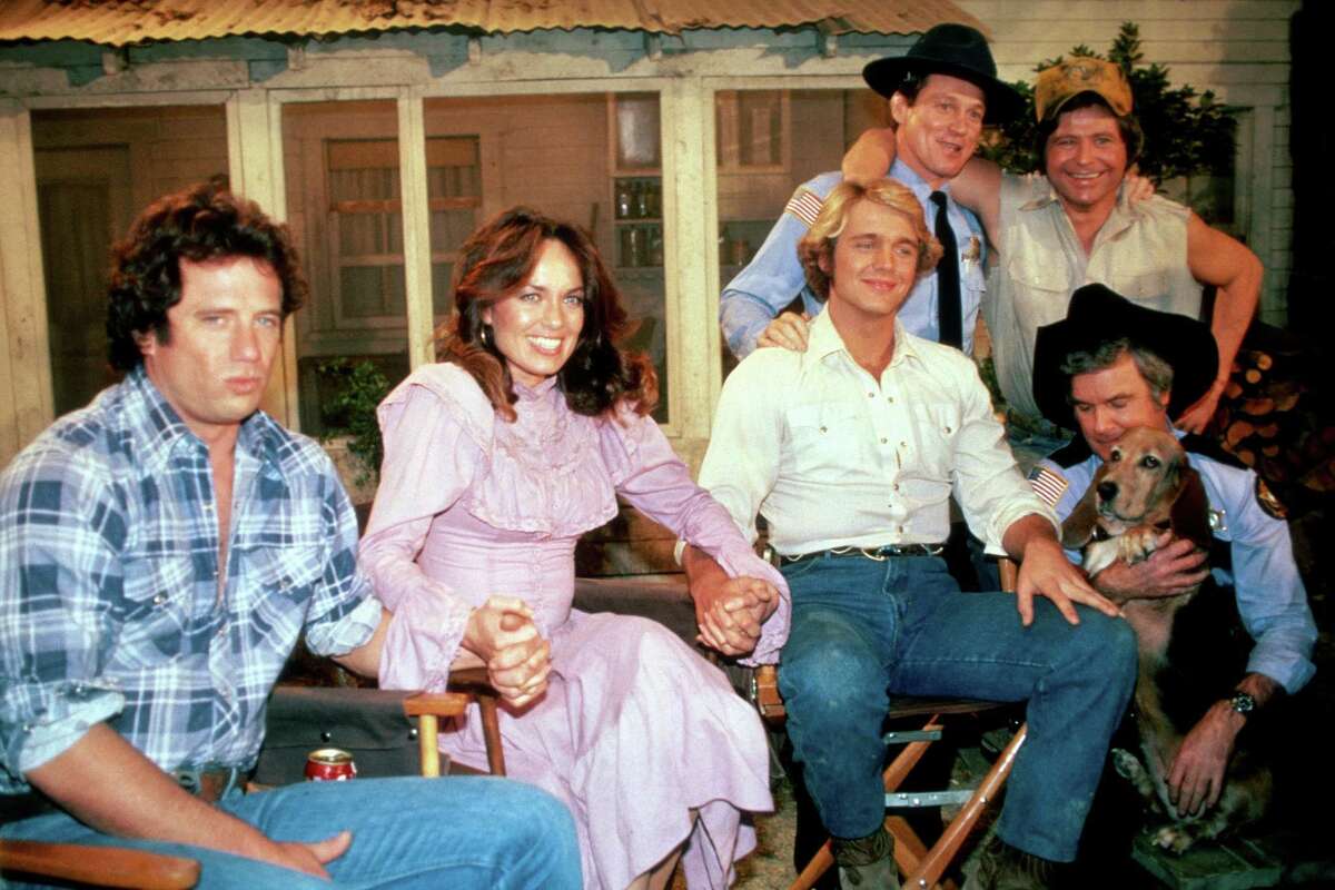 From left, Lucas K. “Luke” Duke (Tom Wopat) Daisy Duke (Catherine Bach) and Beauregard “Bo” Duke (John Schneider) and others during filming of the last episode of “The Dukes of Hazzard” at CBS Studious, Los Angeles, in 1985.
