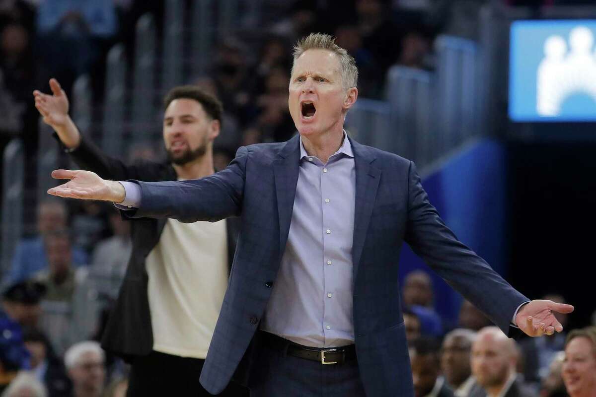 Golden State Warriors head coach Steve Kerr, foreground, and injured guard Klay Thompson react to an official's call during the first half of an NBA basketball game against the Dallas Mavericks in San Francisco, Saturday, Dec. 28, 2019. (AP Photo/Jeff Chiu)