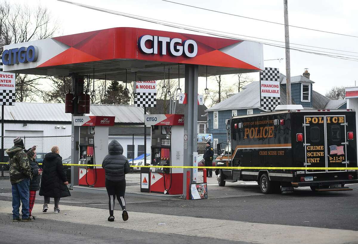 With relatives of the deceased looking on behind a perimeter of police tape, Bridgeport police investigate a homicide at the Citgo service station at 915 Reservoir Avenue in Bridgeport, Conn. on Sunday, January 27, 2019.