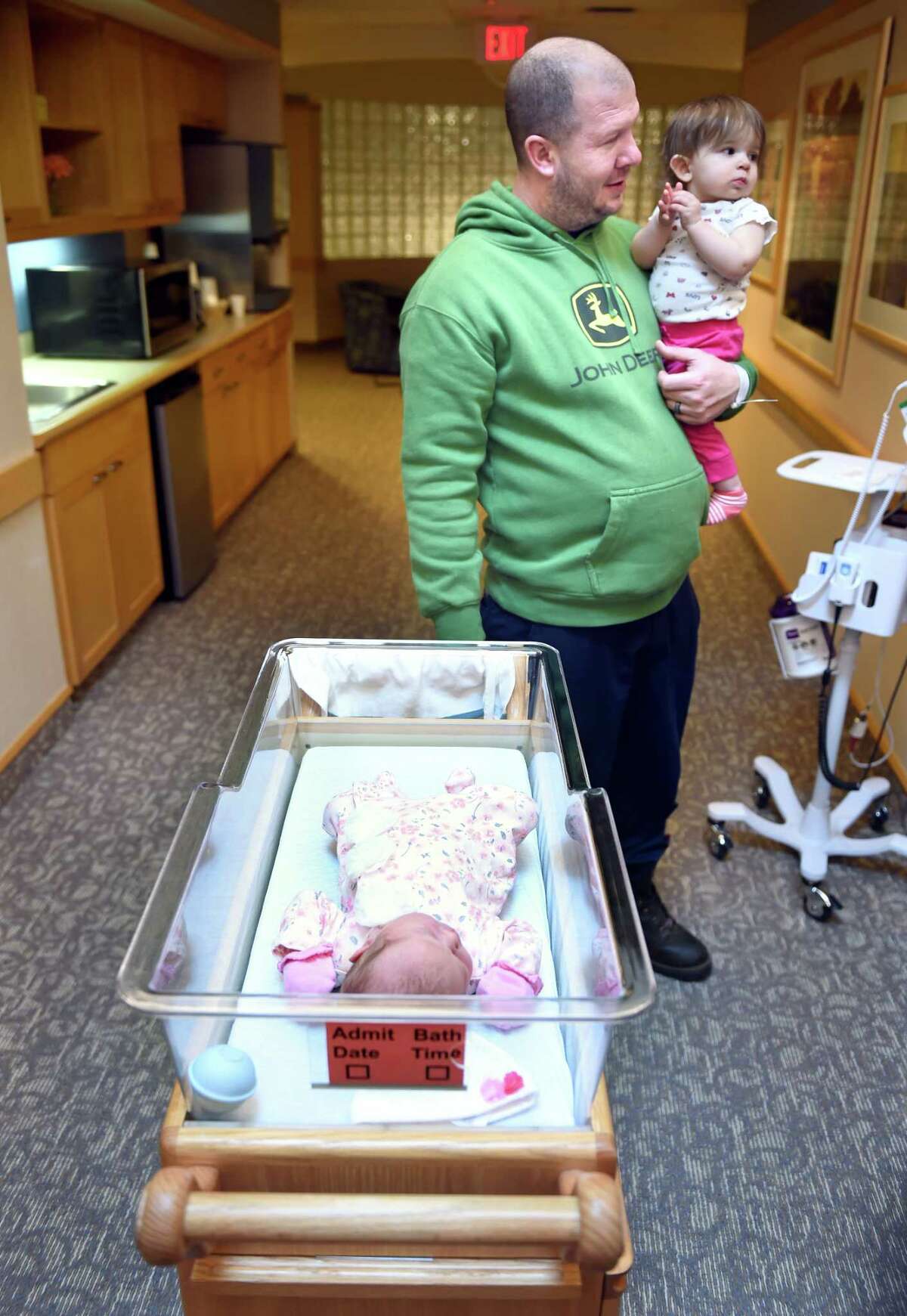Dave Venice of Woodbridge pushes his newborn daughter, Arabella, who was born at 12:04 a.m. on New Year's Day January 1, 2020, to the Family Room at the Childbirth Center at Griffin Hospital in Derby while carrying his other daughter, Emerie, 1. Arabella weighs 8 lb. 6 oz. and is 20.5 inches.