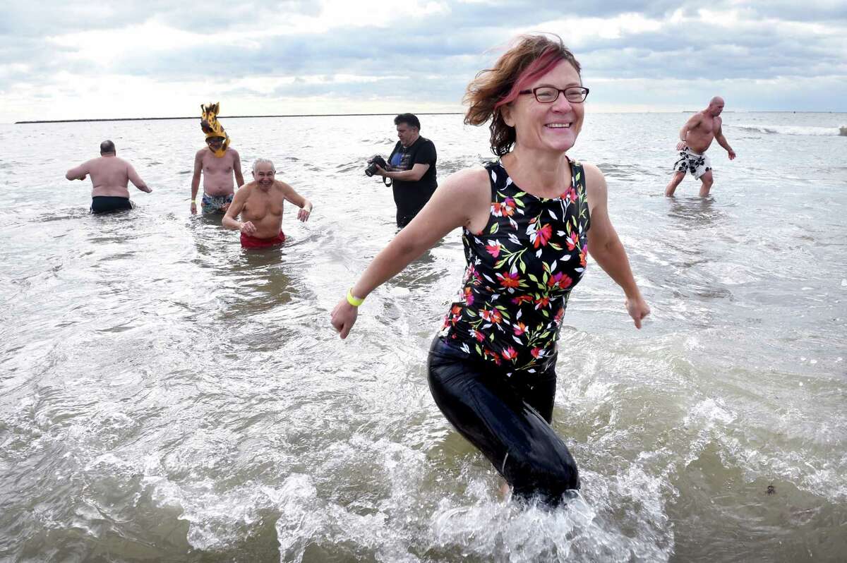 Participants in the annual Plunge for the Parks sponsored by the Elm City Parks Conservancy run into the Long Island Sound at Lighthouse Point Park in New Haven on New Year's Day January 1, 2020.