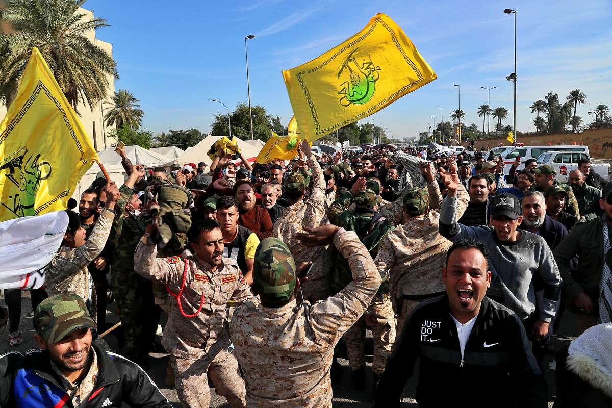 Pro-Iranian militiamen and their supporters chant slogans against the U.S. in front of the U.S. embassy in Baghdad, Iraq, Wednesday, Jan. 1, 2020. U.S. troops fired tear gas on Wednesday to disperse pro-Iran protesters who were gathered outside the U.S. Embassy compound in Baghdad for a second day after dozens of pro-Iranian militiamen and their supporters had camped out overnight at the gates of the embassy. On Tuesday, dozens of the protesters had broken into the compound, trashing a reception area and smashing windows in one of the worst attacks on the embassy in recent memory. (AP Photo/Khalid Mohammed)
