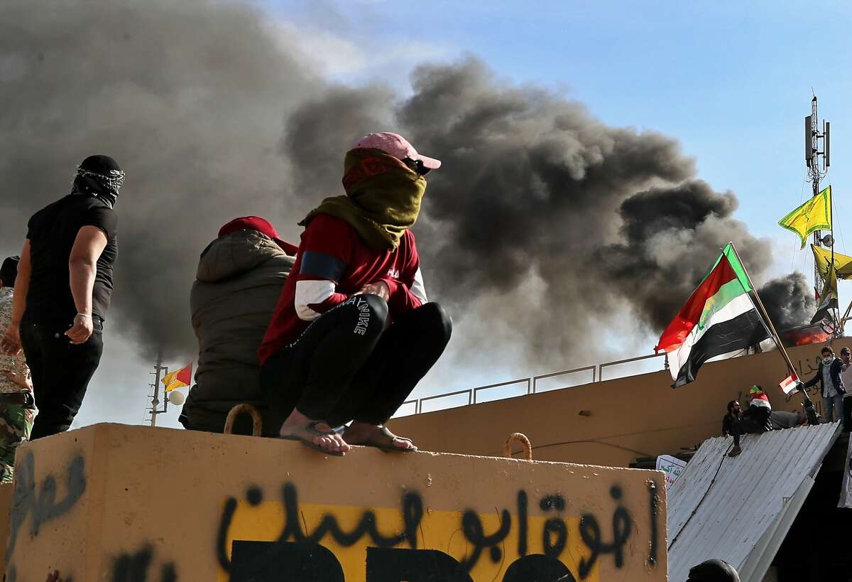 Pro-Iranian militiamen and their supporters set a fire during a sit-in in front of the U.S. embassy in Baghdad, Iraq, Wednesday, Jan. 1, 2020. U.S. troops have fired tear gas to disperse hundreds of pro-Iran militiamen and other protesters who were gathered for a second day outside the American Embassy compound in Baghdad. (AP Photo/Khalid Mohammed)