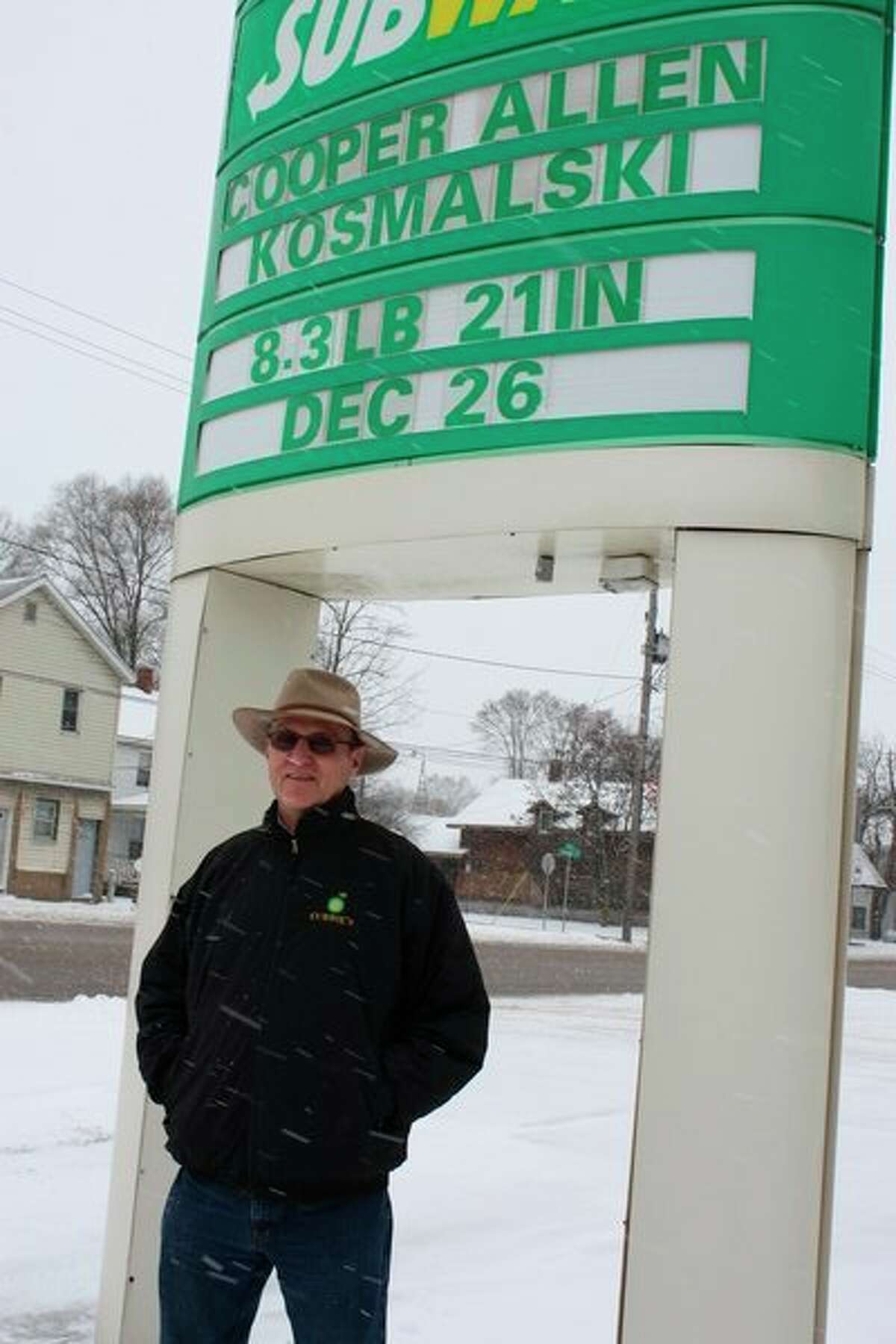 Pat Currie stands underneath the marquee of the BP gas station he owns, 620 Maple St., in Big Rapids. For more than 20 years, Currie has used the marquee to inform drivers and passersby of local news, such as births, deaths, anniversaries and more. (Pioneer photo/Tim Rath)