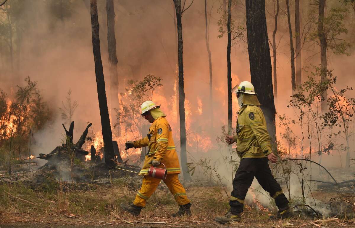 Firefighters create a back burn ahead of a fire front in the New South Wales town of Jerrawangala on January 1, 2020. - A major operation to reach thousands of people stranded in fire-ravaged seaside towns was under way in Australia on January 1 after deadly bushfires ripped through popular tourist spots and rural areas leaving at least eight people dead. (Photo by PETER PARKS / AFP) (Photo by PETER PARKS/AFP via Getty Images)
